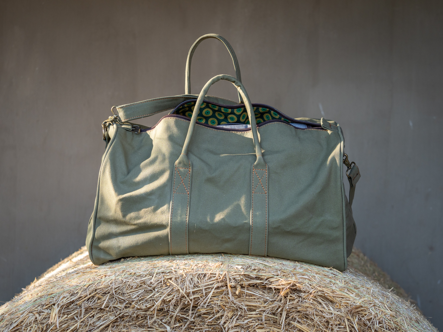 A canvas and leather duffel with a patterned lining